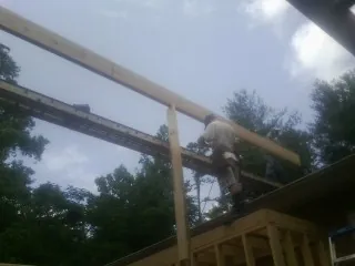 Carpenter setting a ridge beam over a new addition frame — Ice Dam Removal by Roofing Brothers in Cranford