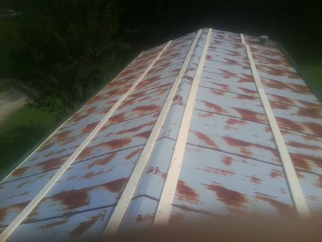 Rusted metal roof panels with new wood purlins before replacement — Storm Damage Roof Repair in Cranford by Roofing Brothers