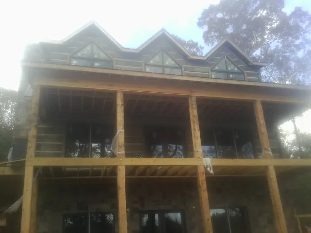 Dormers and porch framing on a large log home under construction — Roof Coating work by our crew in Cranford