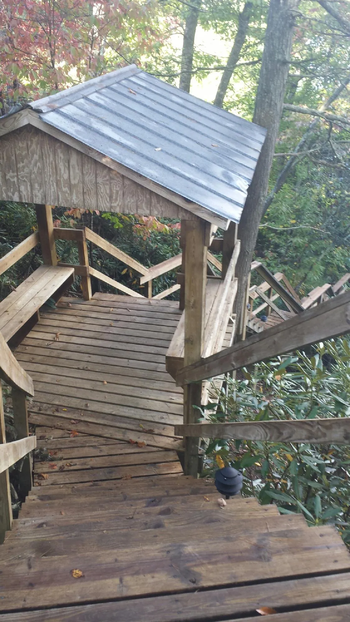 Metal roofed shelter over wooden steps on a wooded walkway — Skylight Repair & Installation work by our crew in Cranford