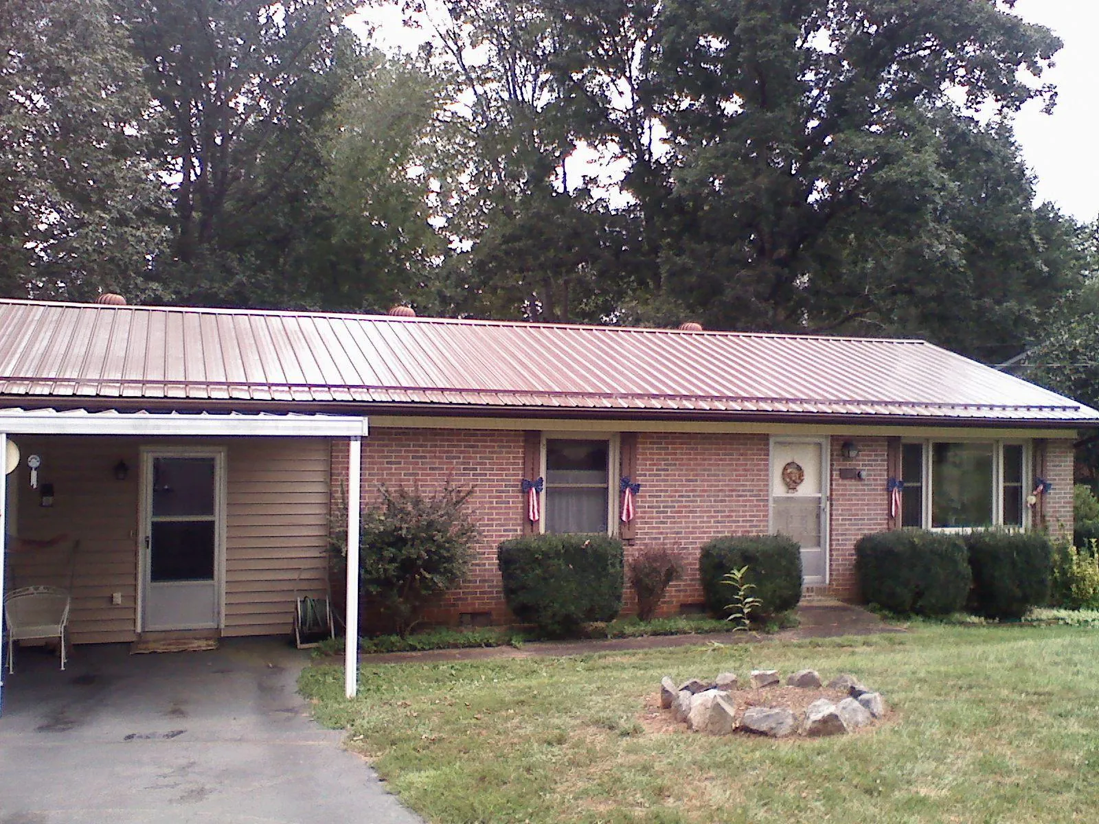 Bronze metal roof and carport on a brick ranch home — Roof Repair work by our crew in Cranford